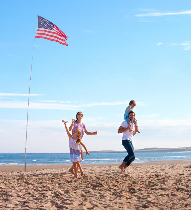 family on beach with extendable flag pole