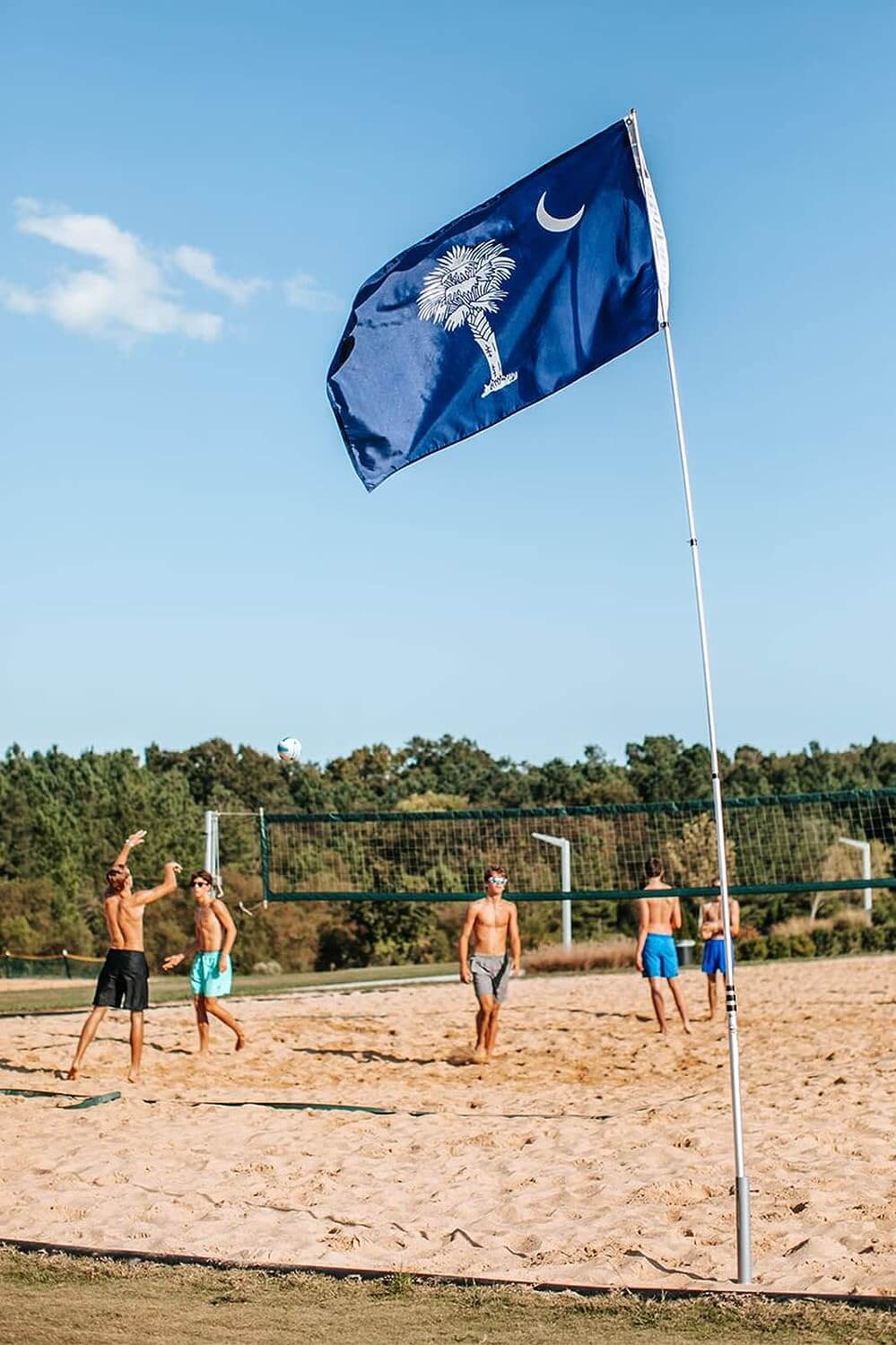 ground flag holder in sand with flagpole and south carolina flag