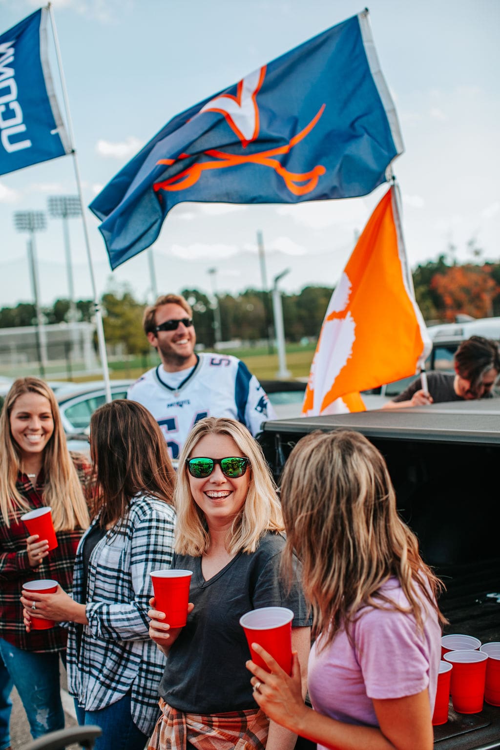 two collegiate flags flying at tailgate
