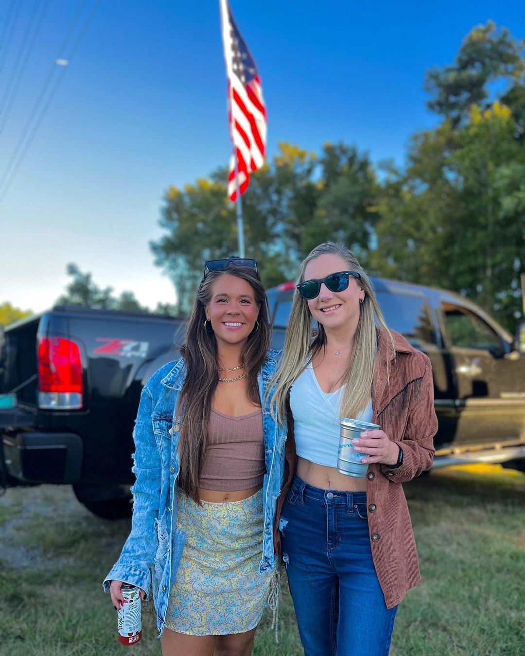 two girls posing in front of america flag